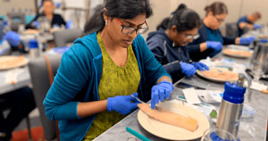 Chica relizando una pracica en el curso de procedimientos dermatológicos