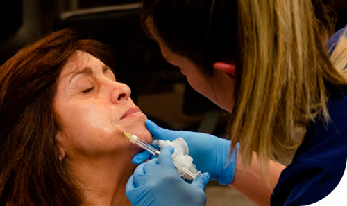 Mujer recibiendo un inyección en el curso de estética médica